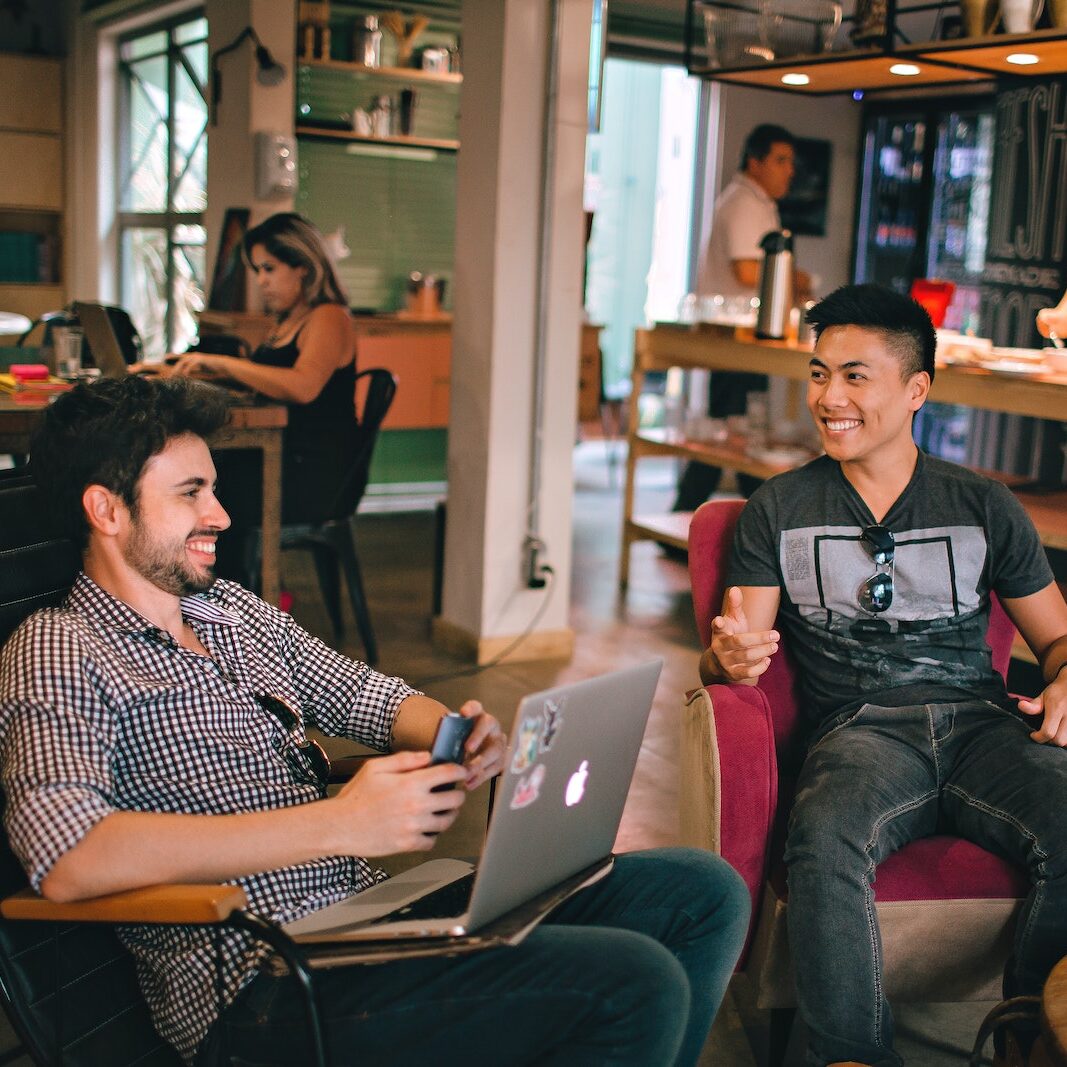 Photograph of Men Having Conversation Seating on Chair